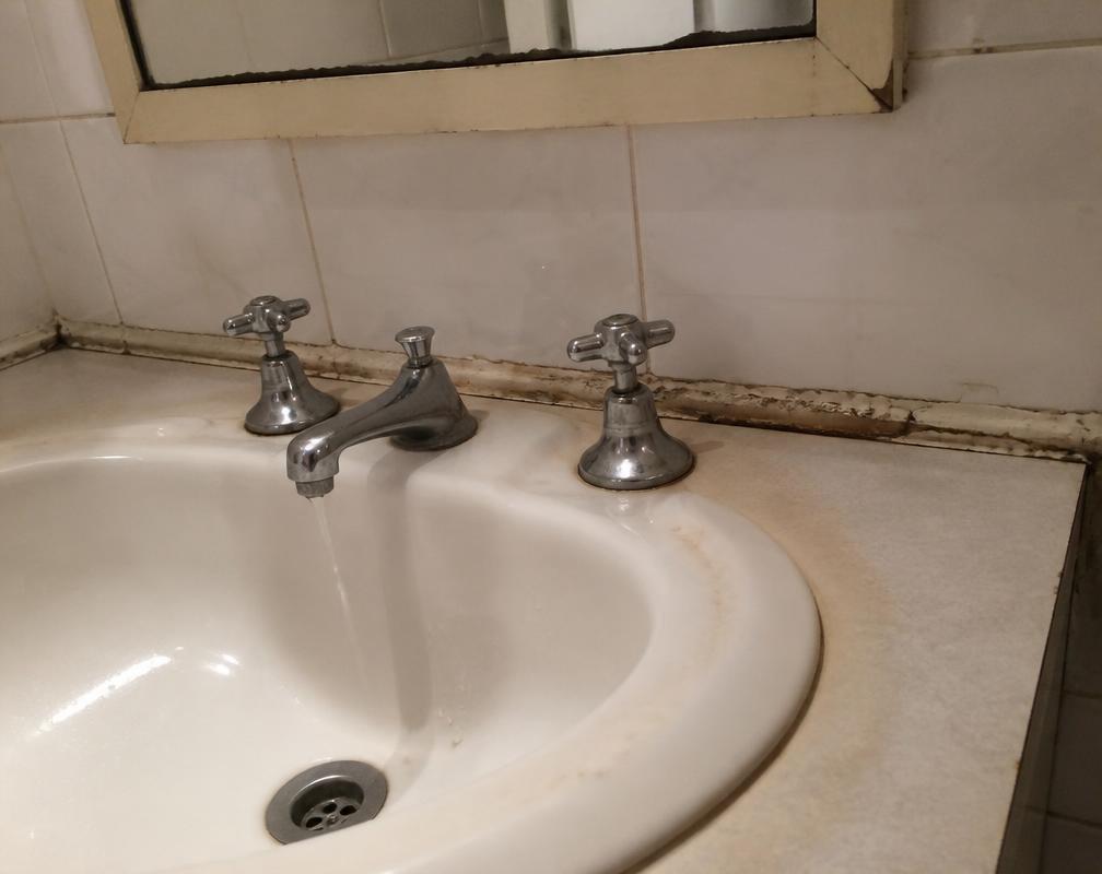 Before: A leaking tap and mouldy, split caulking around the basin. in Glen Abbey, Oakville